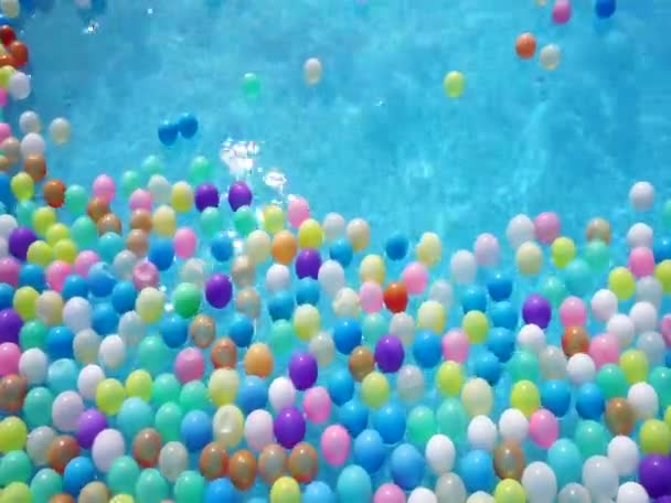 Veel Gekleurde Plastic Ballen Drijven Het Wateroppervlak — Stockvideo