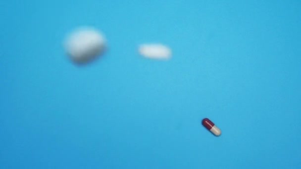 Таблетки Падают Синий Фон Замедленной Съемке — стоковое видео