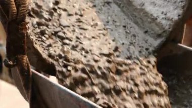 İnşaat inşaatı için çimento kamyonuna sıvı beton dökülüyor..
