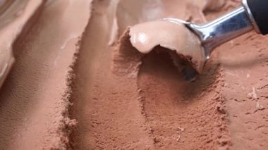 Yakın plan dondurma kepçeleme konteynırdan çikolata aromalı kaşık, tasarım için boş yiyecek konsepti.