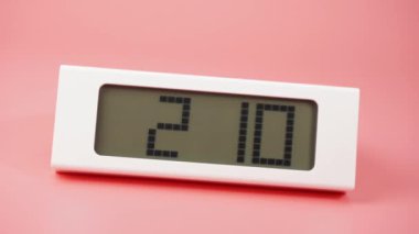 Pembe arkaplanda dijital alarm saati, 60 dakika hızlı hareket ediyor, zaman kavramı.