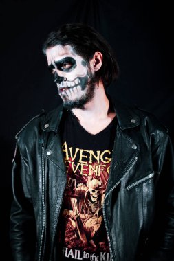 Bir kafatası siyah bir zemin üzerine genç adam kılığında