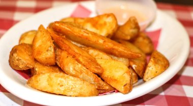 Kızarmış patates dilimleri beyaz tabakta, yakın görüş.