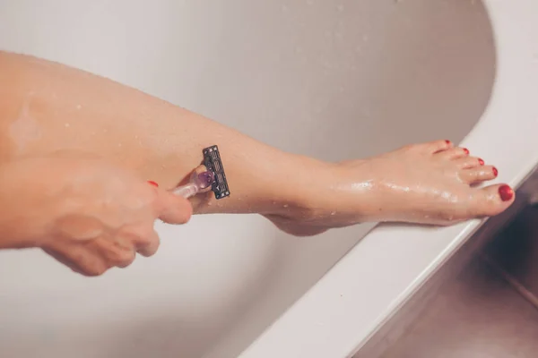 妇女在浴室里刮腿的特写镜头 — 图库照片