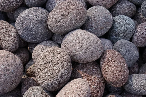 Close-up oval porous stones of brown and gray color.