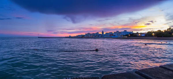 Lido Di Jesolo plaj panoramik manzarası iskelesinden denize ifade gökyüzü ve bulutlar mor, mor ve turuncu renkleri, yaz gecesi, Veneto bölgesinde, İtalya ile üzerinde güzel gün batımı