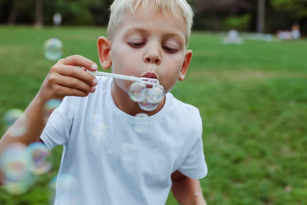 Malý Chlapec Fouká Mýdlové Bubliny Letním Parku — Stock fotografie