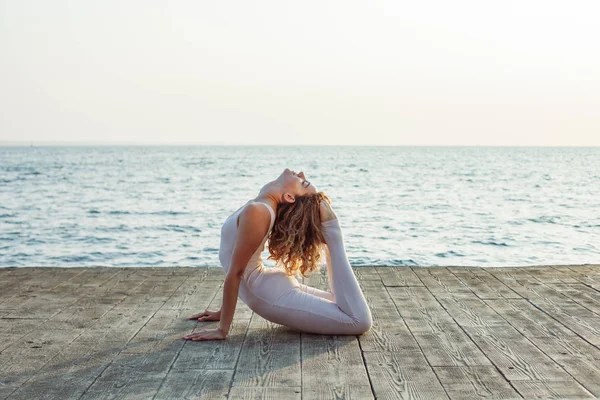 Güneşli yaz gününde çatıda dışında yoga yaparken genç güzel kadın