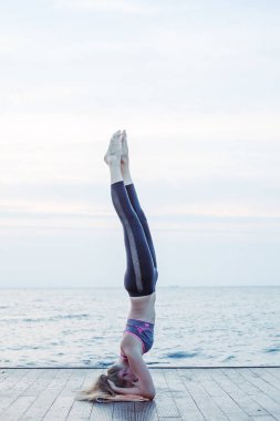Kadın baş stand batımında yoga pose
