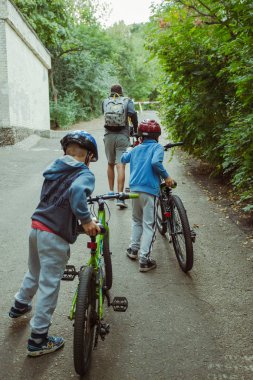 Baba ve çocuklar eğleniyor doğa bir bisiklet sürme