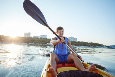 Genç adam bir lak üzerinde bir kayık kürek