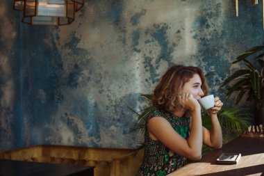 Sabahları restoranda kahve içen bir kadın.