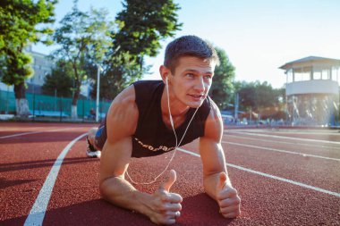 Genç erkek koşucu sporcu antrenmanı yapıyor ve şehir dışında spor yapıyor.