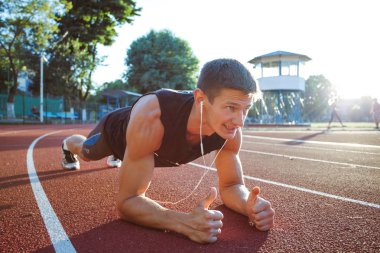 Genç erkek koşucu sporcu antrenmanı yapıyor ve şehir dışında spor yapıyor.