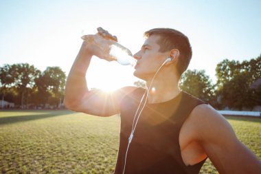 Genç adam bir şişe su içme portresi
