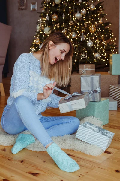 Возбужденная Женщина Открывает Рождественскую Подарочную Коробку Дома — стоковое фото