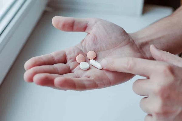 Young man taking vitamins ginseng pill