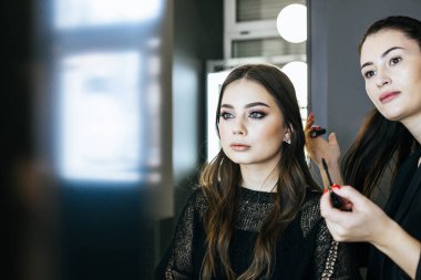 Kozmetik uygulama modeli yüzünde makyaj sanatçısı