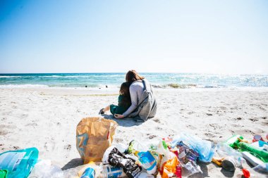 büyük şehrin plajında çöp. Boş kullanılmış kirli plastik şişeler. Kirli deniz kumlu kıyı. Çevre kirliliği. Ekolojik sorun