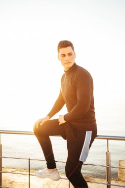 Koşmaya hazırlanan yakışıklı bir adamın portresi, kulaklıklarını takmak