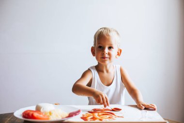 Komik mutlu şef çocuk masada evde pizza pişirme