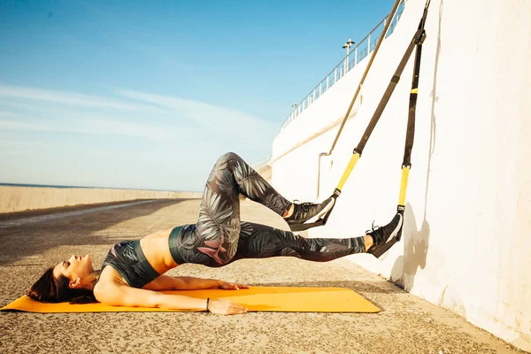 genç sportif kadın açık havada Trx yapıyor
