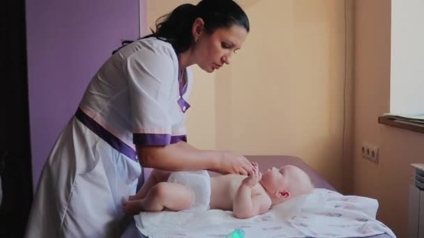 Zdrowe Dzieciństwo Masażysta Masuje Ciało Malucha Stole Salonie Tle Jasnego — Wideo stockowe