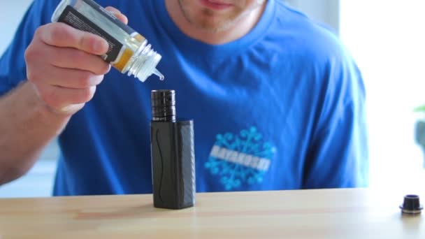 The guy pours liquid into the electronic cigarette — Stock Video