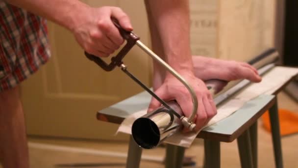 Een man snijdt een metalen been voor de tabel — Stockvideo