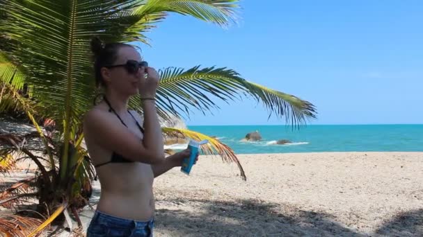 Fille utilise la crème solaire sur la plage — Video