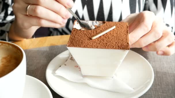 Девушка ест торт тирамису в кафе — стоковое видео
