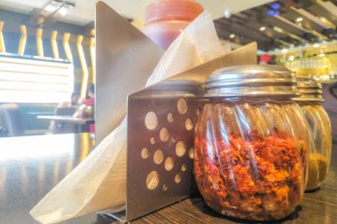 Bir cam şişe mendil'de bir tabloda bir restoran ile baharat pizza