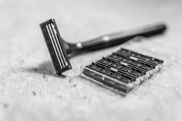 Man\'s shaving machine with a pack of extra blades in black and white