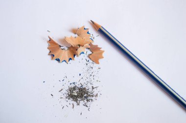 Bir kalem kalem ile bilenmiş kabukları ve beyaz bir arka plan üzerinde atık siyah grafit kurşun