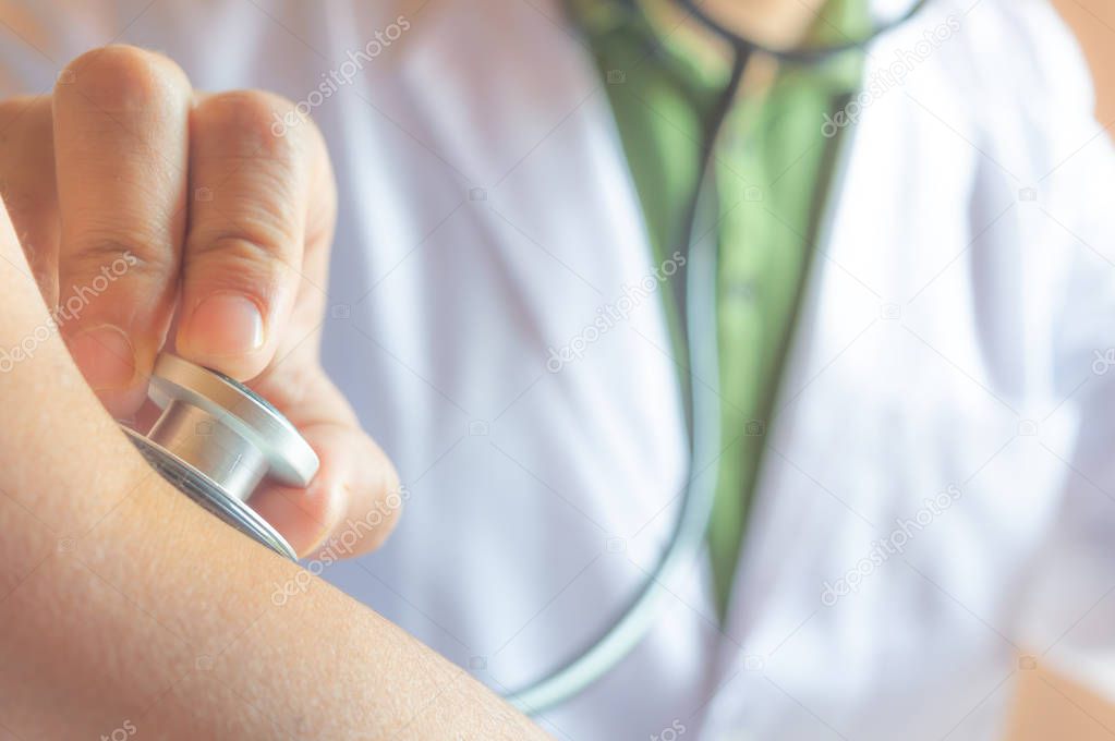 A doctor checking the pulse of a patient with his stethoscope