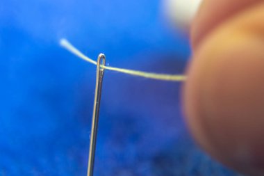 İş parçacığı bir iğne geçiş yapmaya çalışan bir kişi