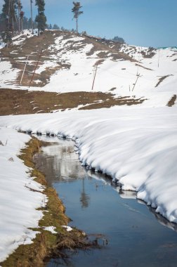 Kar manzara içinde belgili tanımlık geçmiş bir tepe ile bir küçük narow dere
