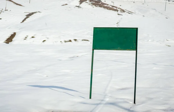 A sign board copy space board in a white snow landscape