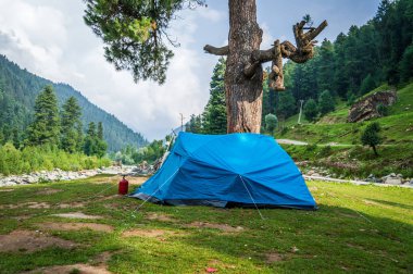 Keşmir Himalaya bölgesinde kamp için mavi renkli çadır kurmak