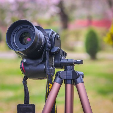 Srinagar, Jammu ve Keşmir, Hindistan- Tarih: 15 Haziran 2019: Alüminyum tripod üzerine monte edilmiş Bir Nikon D3200 Dslr fotoğraf makinesi. Arka plan odak dışında.