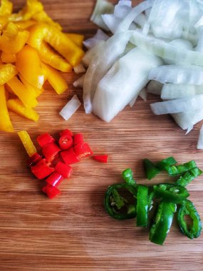 Chillis sarı biber ve soğan yemek pişirmek için bir kesme tahtası üzerinde.