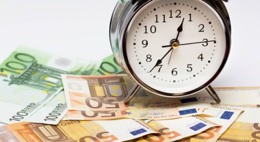 Bir çalar saat ve beyaz zemin üzerine Avrupa kağıt para. İş kavramı, vakit nakittir.