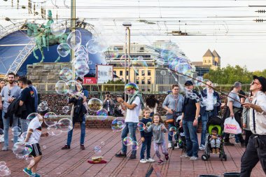 Köln, Almanya - 06 Ekim 2018: kabarcıklar üfleme bir adam izliyor turist yürüme. İyi bir gün.