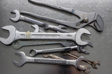 Siyah parlak tabloya yukarıdan düz görünüm yatan metal düz somun anahtarları.