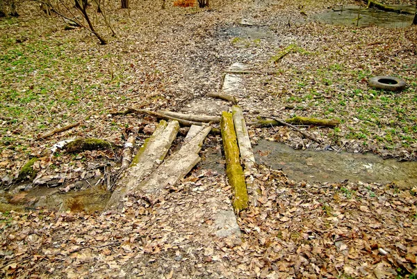 Le pont pourri à travers un ruisseau — Photo