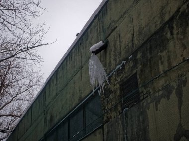 bir duvar bir su boru üzerinden buz sarkıtları