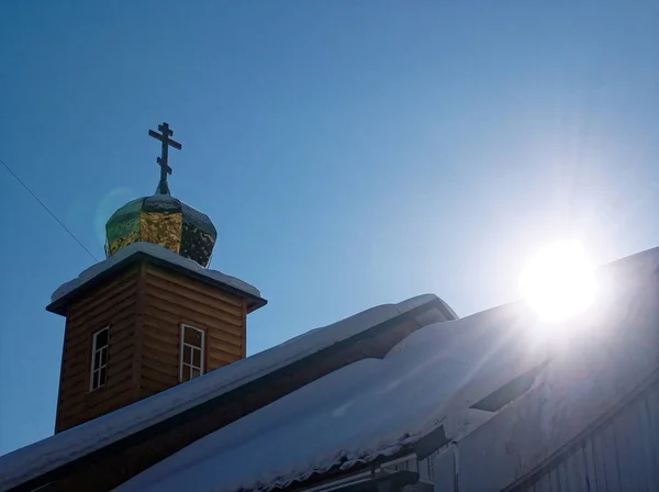 Деревянная православная церковь зимой против голубого неба — стоковое фото