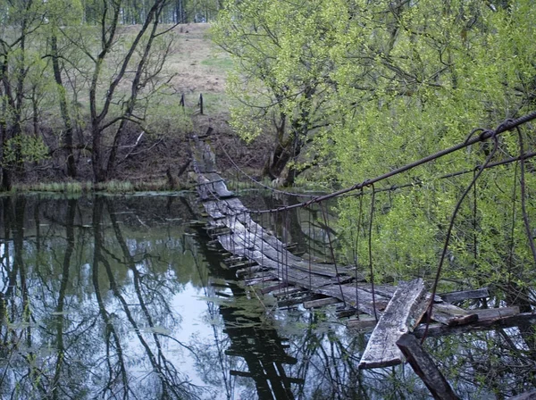 broken suspension bridge on spring evening , Russi