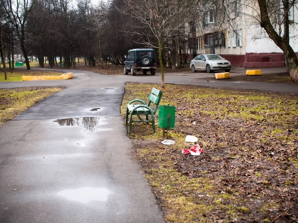 Pasarela pavimentada en el parque lleno de basura — Foto de Stock