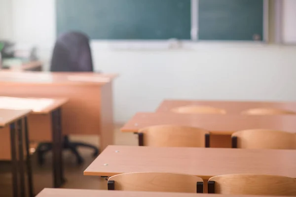 School classroom in blur background without young student. Blurry view of class room no kid or teacher with chairs and tables in campus.